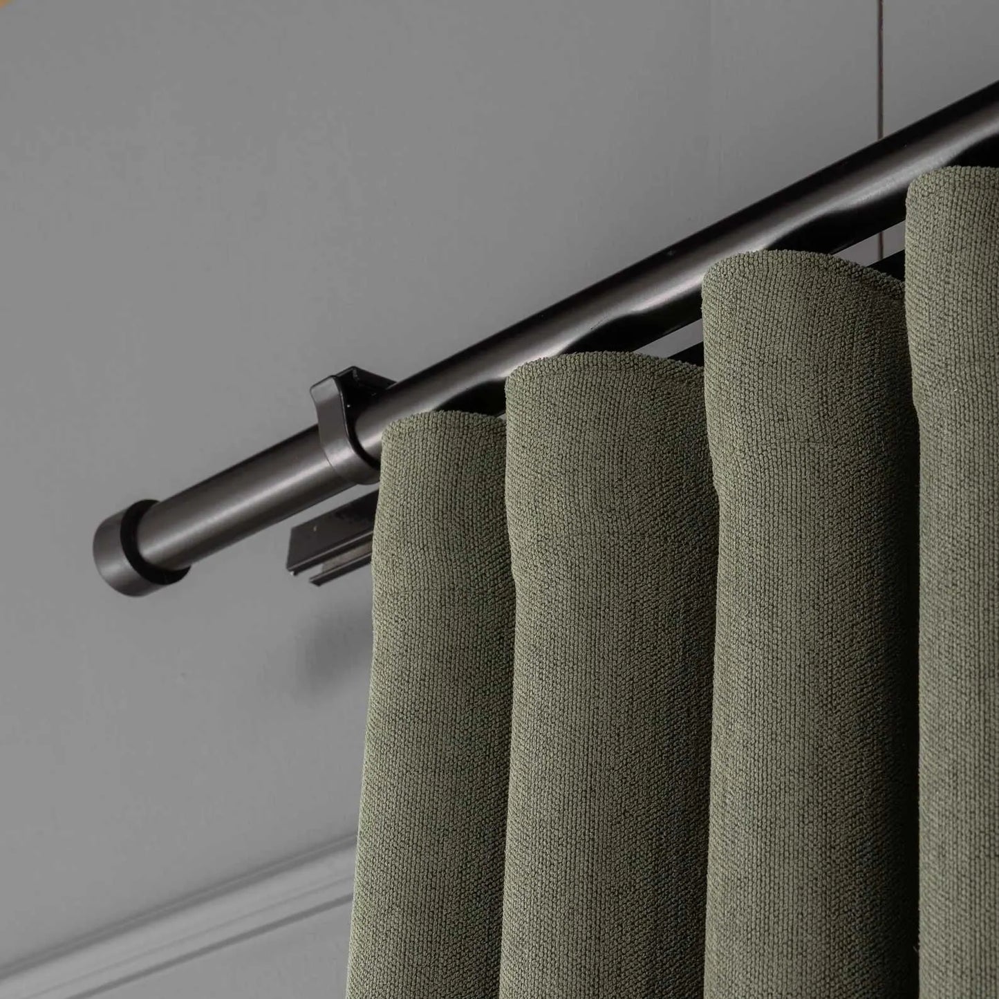 Close-up view of the linen texture and pleats of 100% Blackout Pleated Linen Curtain Panels in Olive Green.